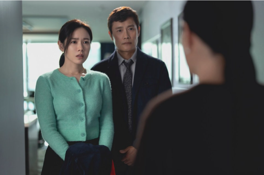 이 스틸컷은 영화 어쩔 수가 없다에서 유만수(이병헌)와 아내 이미리(손예진) 부부가 누군가를 마주하고 놀란 듯한 표정을 짓는 장면입니다.